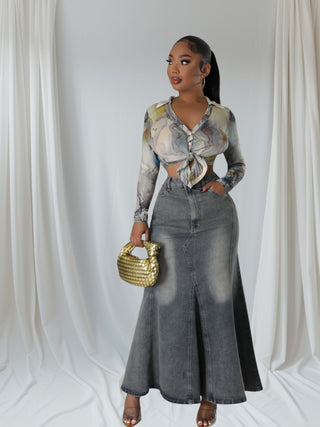 Model wearing a high-waisted gray denim maxi skirt with a dramatic flare hem and front seam detail.