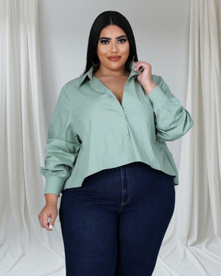 Plus-size woman wearing mint green button-down shirt with pleated back and rolled sleeves — Tulley’s Boutique
