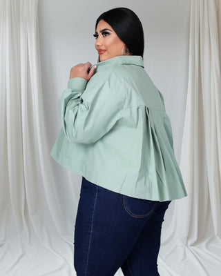 Plus-size woman wearing mint green button-down shirt with pleated back and rolled sleeves — Tulley’s Boutique