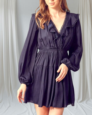 Woman wearing Let It Flow Mini Dress front view — black long-sleeve dress with flowy silhouette.