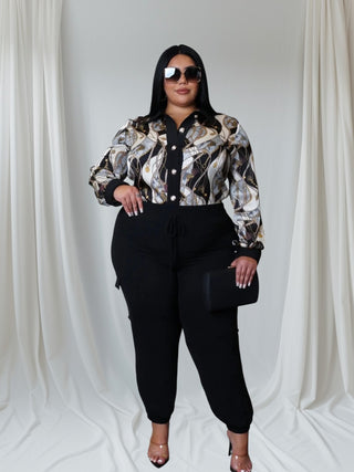 Woman wearing a long, flowy watercolor print top tucked into jeans — Watercolor Dreams Top from Tulley’s Boutique.