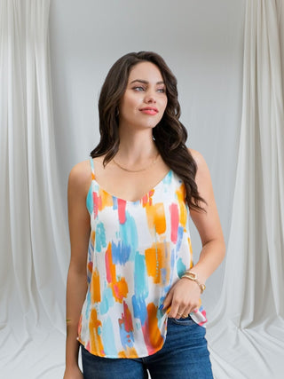 Woman wearing colorful watercolor print camisole with adjustable straps — Watercolor Dreams Cami from Tulley’s Boutique.