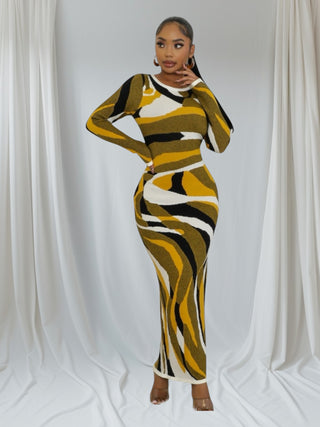 Woman wearing gold, black, and white swirl pattern bodycon maxi dress with long sleeves