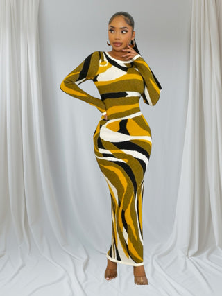 Woman wearing gold, black, and white swirl pattern bodycon maxi dress with long sleeves
