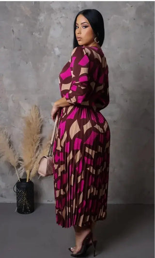 model wearing It’s My Season Maxi Dress — geometric mocha and fuchsia print with pleated skirt and belt.