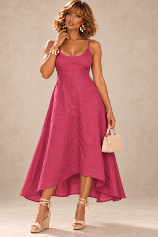 Woman in a fuchsia Italian linen sundress with a scoop neckline, spaghetti straps and a high-low hem, worn with espadrille wedges