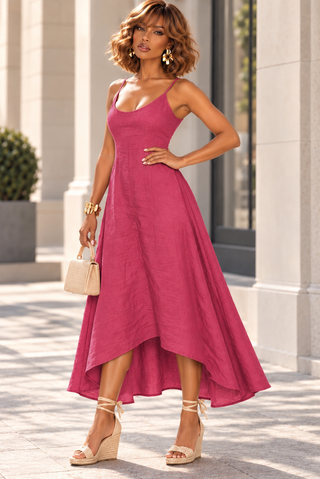 Front view of a fuchsia Italian linen high-low midi dress showing the flared A-line skirt in motion
