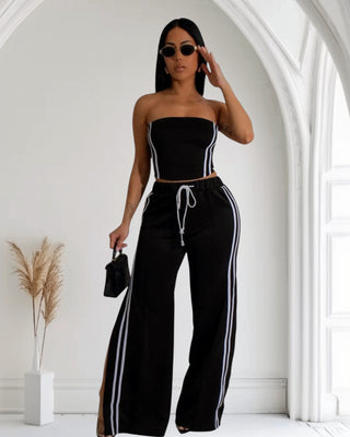 Model wearing a sleek black and white striped two-piece set featuring a tube top and high-waisted wide-leg pants, exuding elegance.