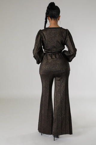 Model wearing black metallic two-piece pant set with tie-waist blouse and wide-leg pants