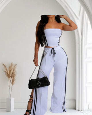 Model wearing a sleek White and Black striped two-piece set featuring a tube top and high-waisted wide-leg pants, exuding elegance.