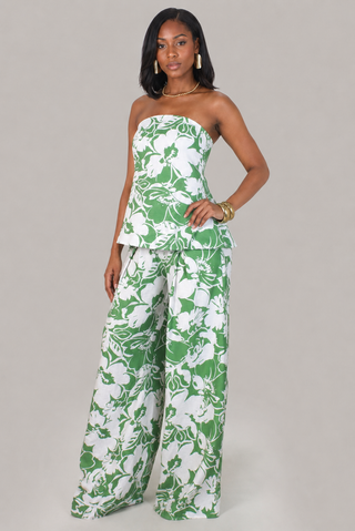 Model wearing the Palm Luxe green and white floral strapless peplum top and wide-leg pants set