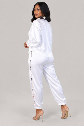 Back view of ivory satin two-piece set showing check collar detail and striped side seam down the pants