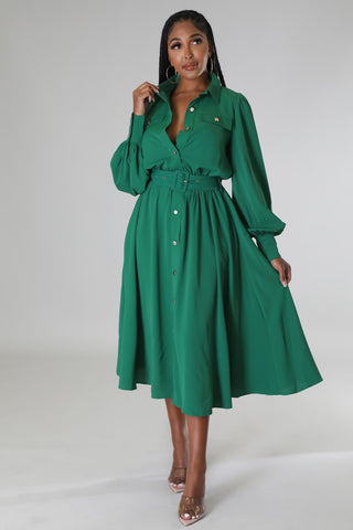 Woman wearing a green dress with a belt on a white background