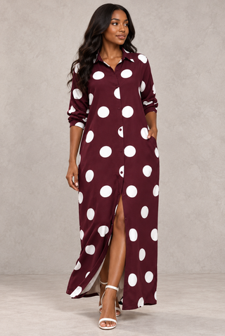 Front view of a burgundy long sleeve maxi shirt dress with oversized white polka dots and a full button front
