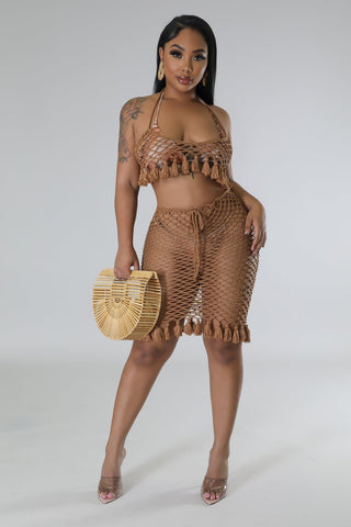 model wearing tan crochet two-piece halter top and drawstring skirt set