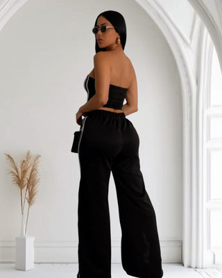 Model wearing a sleek black and white striped two-piece set featuring a tube top and high-waisted wide-leg pants, exuding elegance.