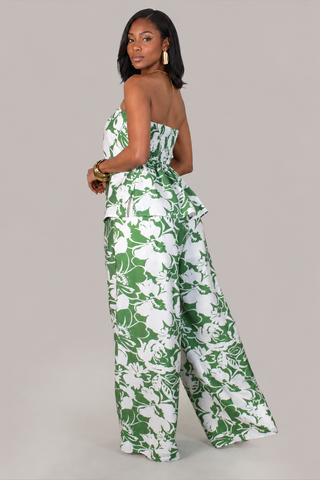 Model wearing the Palm Luxe green and white floral strapless peplum top and wide-leg pants set back view