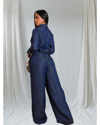 "Model showcasing a stylish navy blue denim jumpsuit with a wrap design and wide-leg pants- tie string to snatch waist