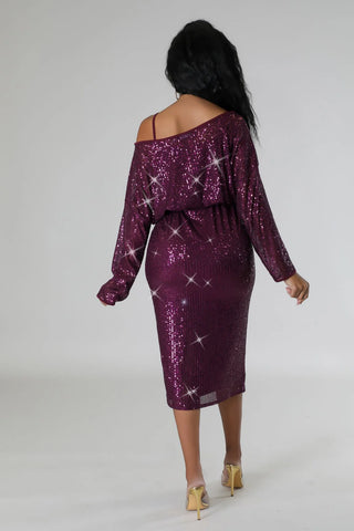 Woman wearing a purple off-the-shoulder sequin stretch midi dress with spaghetti strap underlining.
