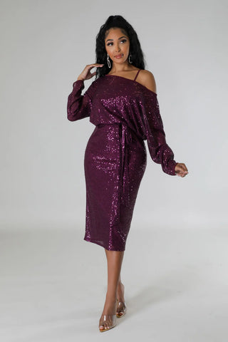 Woman wearing a purple off-the-shoulder sequin stretch midi dress with spaghetti strap underlining.