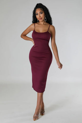 Woman wearing a purple off-the-shoulder sequin stretch midi dress with spaghetti strap underlining.