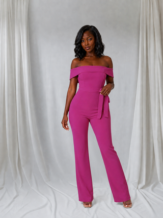 Front view of pink petite off\-shoulder jumpsuit with self\-tie waist and flared legs