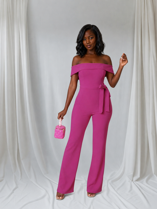 Styled front pose of pink petite jumpsuit featuring a fitted bodice and 30-inch inseam