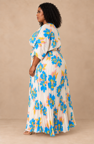 side view of ivory plus-size floral pleated maxi dress with blue, yellow, and blush print and full pleated skirt