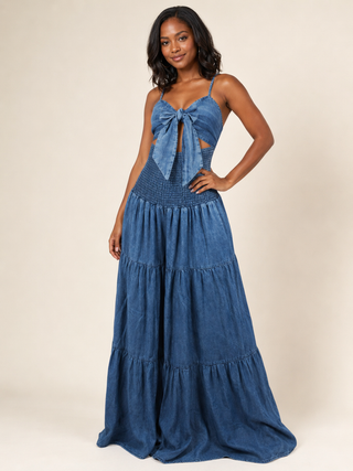 Blue acid wash tie-front denim jumpsuit styled with a bow and tiered wide legs