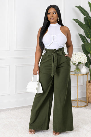 Model wearing olive green paperbag waist wide-leg denim pants with tie belt and white sleeveless top, front view
