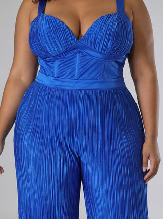 Close-up of the Elegant royal blue satin jumpsuit showing the pleated V-neck bodice, structured seamed midsection, satin waistband and fine vertical pleats on the wide legs