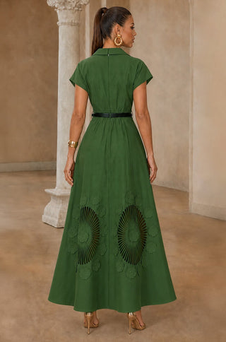 Model wearing a green collared maxi dress with a V-neck, defined waist and floral cutwork design near the hem.