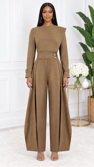 Model wearing the Mocha Allure petite fit set, mocha brown crew neck top with asymmetric shoulder panel, snap waistband and pleated wide-leg pants, front view