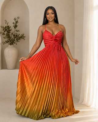 Model in the Moment of Truth dark orange ombre pleated maxi dress holding out the flowing satin skirt