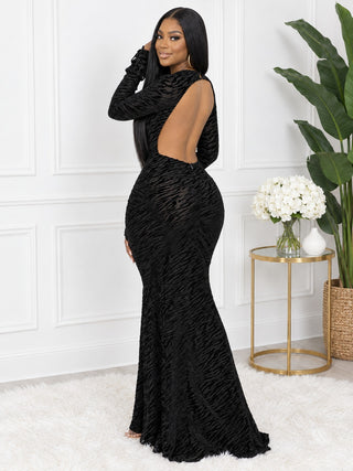 Side-back view of black open-back maxi party dress showing the dramatic rounded back cut-out