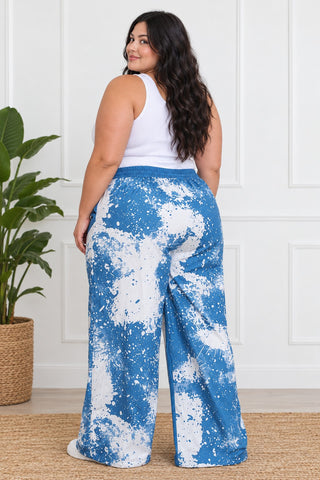 Back view of plus size blue and white all-over paint-splash wide-leg pants with elastic waistband