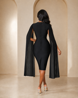 Back view of petite black bandage midi dress with long pleated cape sleeves and center zipper