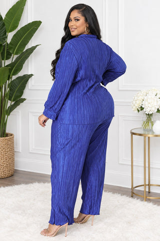 Side-back view of plus size royal blue pleated pants set showing long sleeves and relaxed pant leg