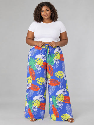 Front view of plus size blue tropical print pants with adjustable drawstring tie and full-length wide legs