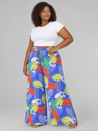 Side view of plus size royal blue palm and monstera print palazzo pants showing flowy wide leg