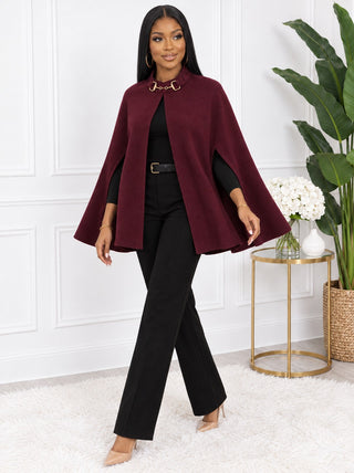 Model walking in the burgundy cape with one arm through the side arm slit, showing the A-line swing shape