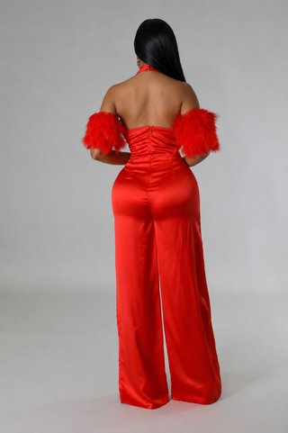 Back view of red satin jumpsuit showing the open back and center zipper closure