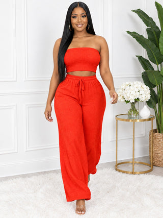 Woman walking in bright orange matching crop top and wide-leg pants set – Tulleys Boutique