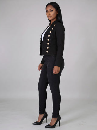 Side profile of a black cropped military jacket showing the fitted waist-length cut and long sleeves