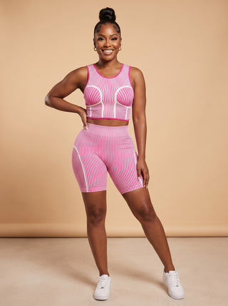 Model wearing the Pink Contour Sculpt striped seamless crop tank and high-waisted biker shorts set with white sneakers, front view